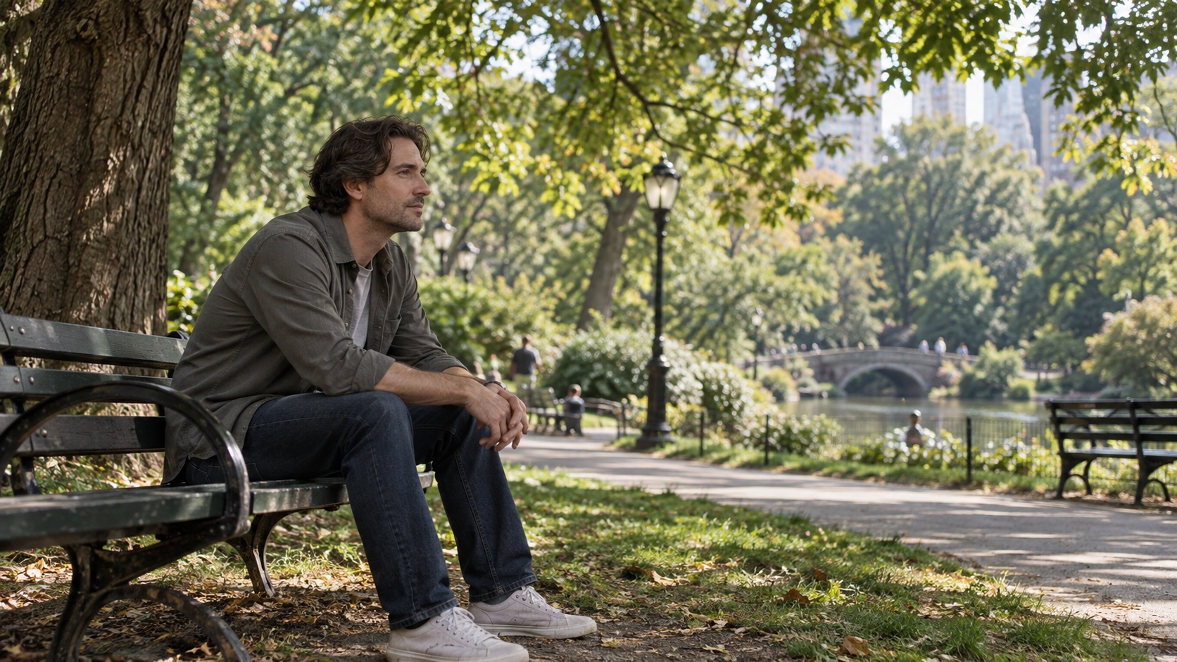 An adult sits quietly on a park bench.