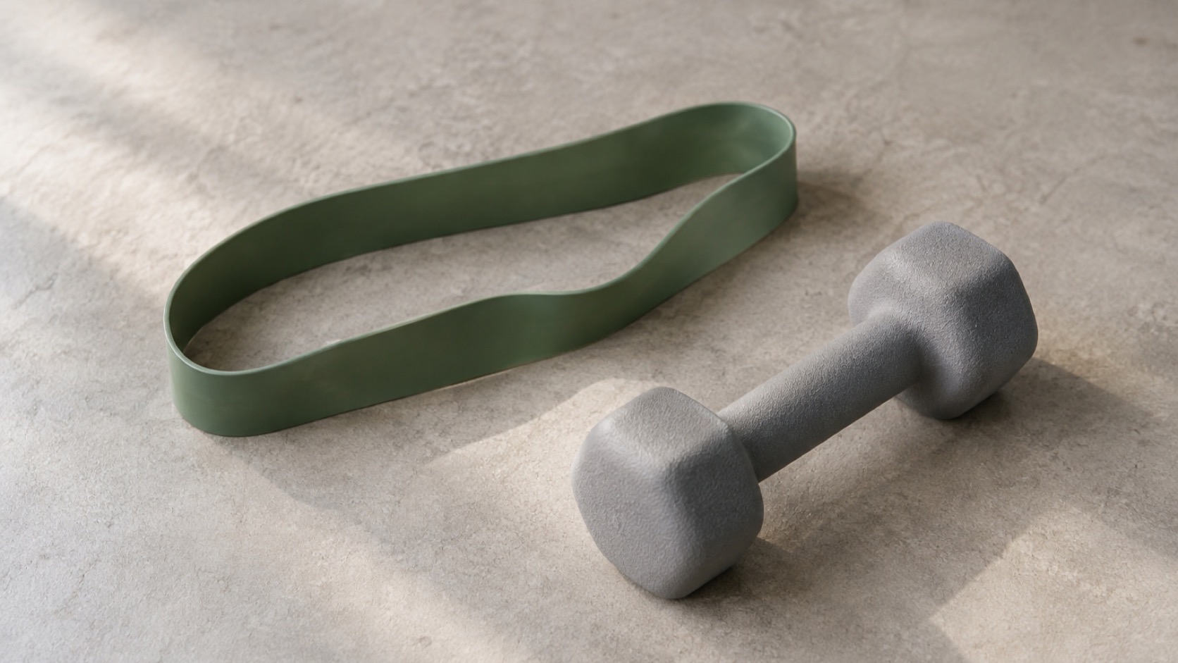 A resistance band beside one light dumbbell.