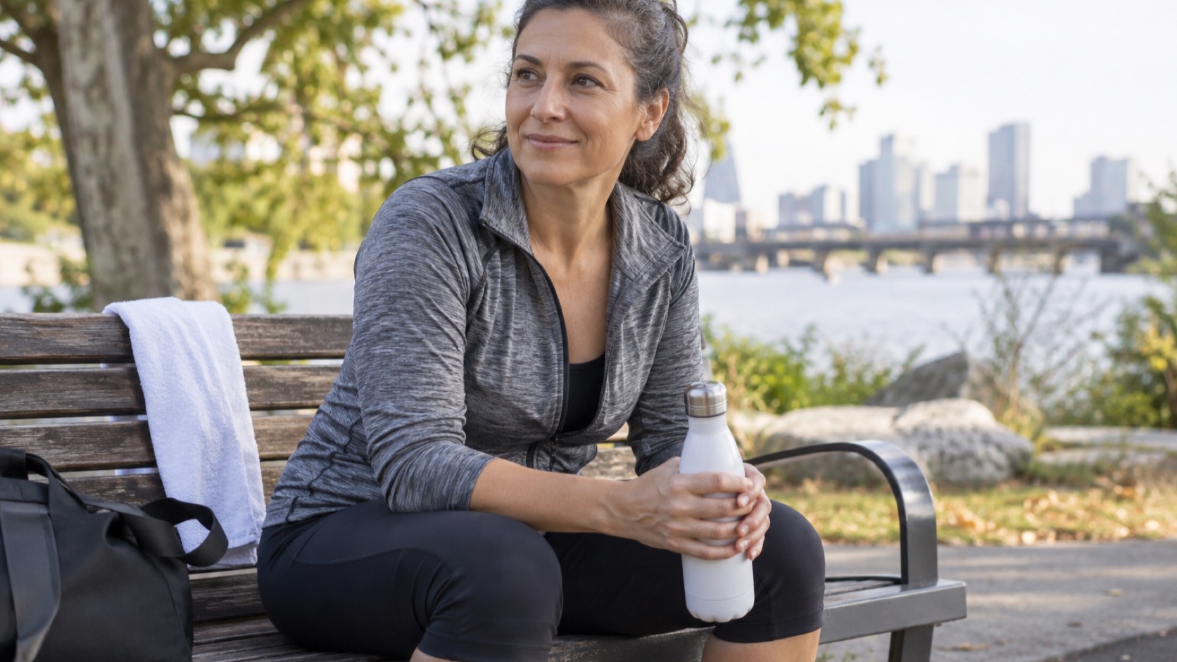 Adult sits quietly with a glass of water after exercise.