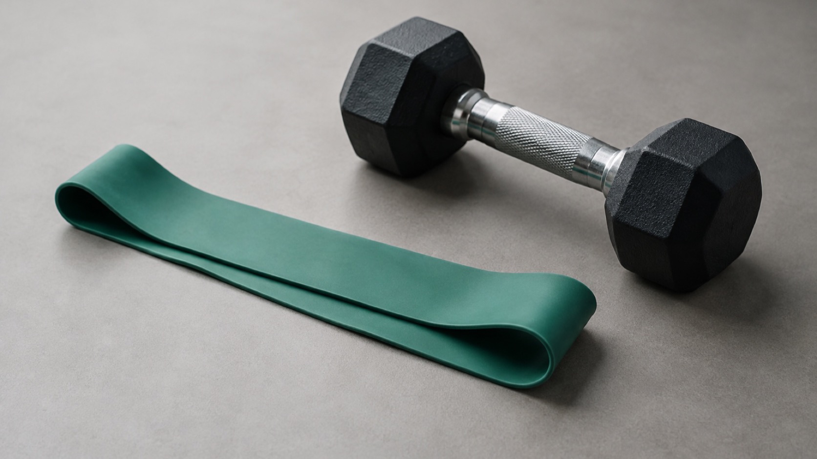 Resistance band and dumbbell on a gym floor.